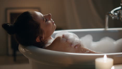 Romantic-woman-chilling-foam-bath-at-home-closeup.-Groomed-naked-girl-having-spa