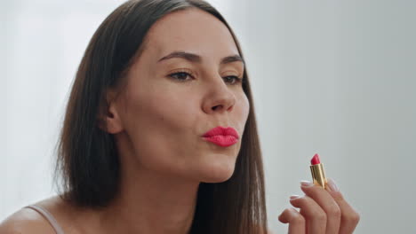 Happy-girl-makeup-routine-bathroom-closeup.-Woman-applying-red-lipstick-visage
