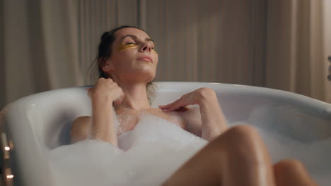 Charming-lady-laying-bubble-bath-relax-evening-house.-Close-up-woman-skin-care