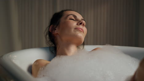 Sensual-model-enjoying-spa-routine-at-evening-bathroom.-Calm-woman-touching-body