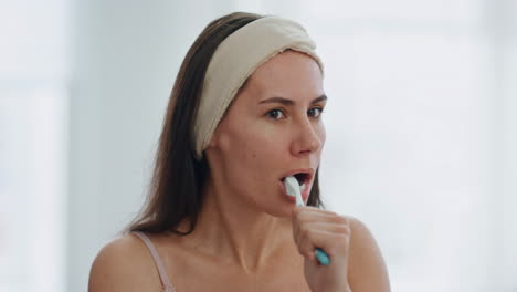 Entspannte-Dame-Putzt-Morgens-Im-Innenbereich-Die-Zähne,-Nahaufnahme.-Tägliche-Zahnpflege