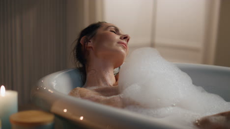Calm-lady-relaxing-foam-bath-closeup.-Relaxed-woman-washing-naked-body-alone