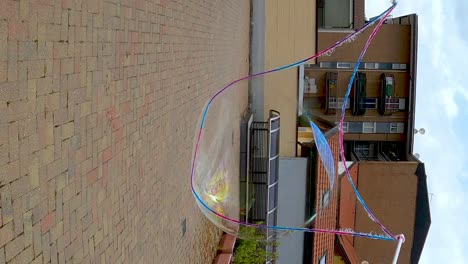 First-person-view-of-male-hands-using-long-sticks-and-rope-to-create-big-soap-bubble