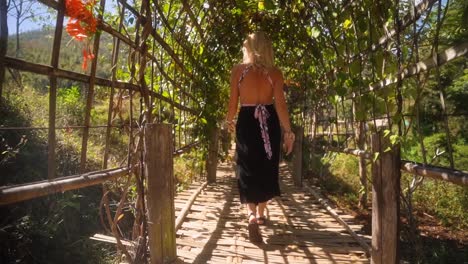Beautiful-blond-caucasian-European-woman-walking-over-a-Bamboo-bridge-in-the-mountain-village-Pai-in-Thailand-on-a-warm-summer-day