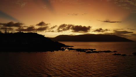 Sunsetting-behind-an-island-making-a-bright-orange-sky