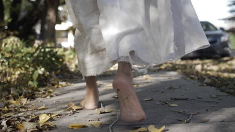 A-dramatic-slow-motion-closeup-of-Jesus'-feet-walking-down-a-sidewalk-while-he-wears-a-white,-tattered-robe
