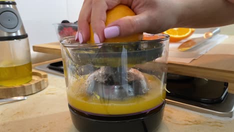 Nahaufnahme-Der-Weiblichen-Hand,-Die-Frische-Orange-Mit-Saftpresse-Auspresst,-Gesundes-Frühstück