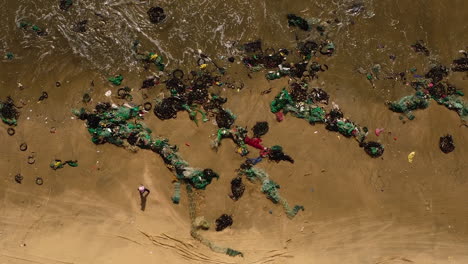 aerial-top-down-of-ocean-pollution-plastic-fishing-net-on-ocean-tropical-sandy-beach-after-monsoon-storm,-industrial-agricultural-marine-pollution-concept