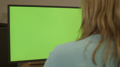 Dolly-of-woman-sitting-behing-a-green-computer-screen