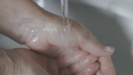 A-woman-carefully-washes-her-hands-under-tap-water