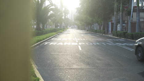 Beautiful-slow-motion-shot-of-a-lonely-area-of-Lima-Peru-during-sunset-as-a-car-crosses-the-road
