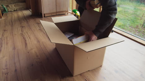 Put-books-in-cardboard-box-,-prepare-for-the-move-,-Medium-shot