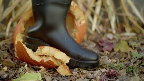 Halloween-jack-o'-lantern-being-stomped-twice-by-a-person-wearing-a-black-rubber-boot
