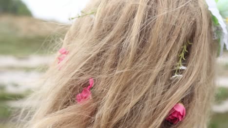 Close-up-of-cheerful-flowers-braided-in-a-blond-woman's-hair