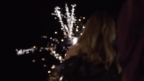 Close-up-shot-of-a-young-attractive-woman-watching-a-firework-display-in-the-dark