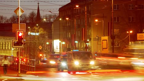Timelapse-of-city-rush-hour-traffic-over-the-Liepaja-tram-bridge,-city-landscape-after-the-sunset,-traffic-light-streaks,-fast-moving-trams,-distant-medium-shot