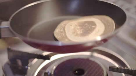 Shaking-pan-with-cooked-pancake-to-cool-down-closeup