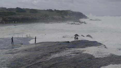 Friends-having-fun-with-waves-during-a-storm---Clovelly-Beach-Sydney-Australia