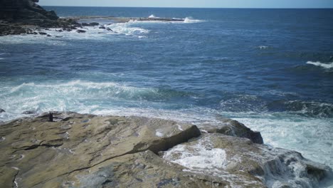 White-waves-splashing-on-the-rocks---Clovelly-Beach,-Australia---wide