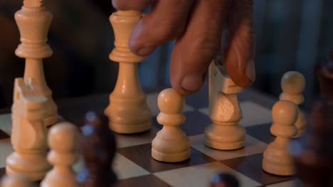 Man-Skillfully-Positions-Knight-Unto-Chessboard---close-up-shot