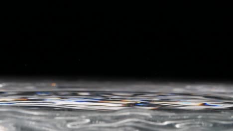 Drops-of-water-falling-in-a-clear-water-pool--close-up