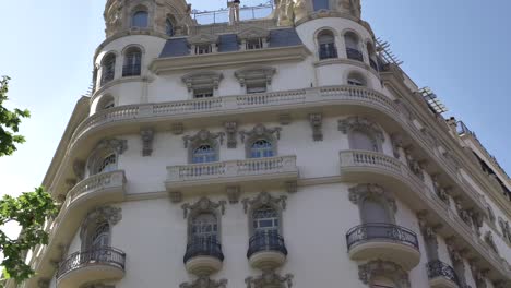 Elegant-old-fashioned-historic-Barcelona-apartment-building-with-vintage-balcony-windows-pan-down