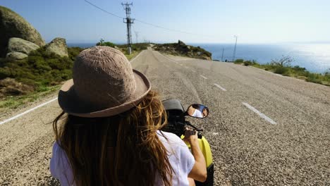 Beautiful-woman-wearing-a-hat-driving-an-ATV-on-the-island-,-summer-time
