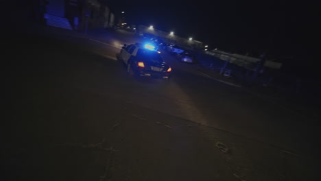 Cinematic-slow-motion-shot-of-two-police-cars-pulling-over-a-car-at-nighttime