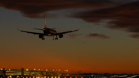 Tracking-shot-of-commercial-plane-landing-at-Barcelona-airport-at-twilight