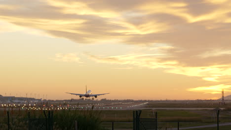 Slow-pan-right-shot-of-commercial-plane-landing-at-Barcelona-airport-at-sunset