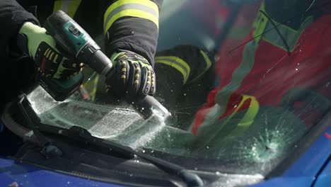 Cutting-windshield-during-rescue-operation-of-firefighters-after-a-car-accident-in-slow-motion