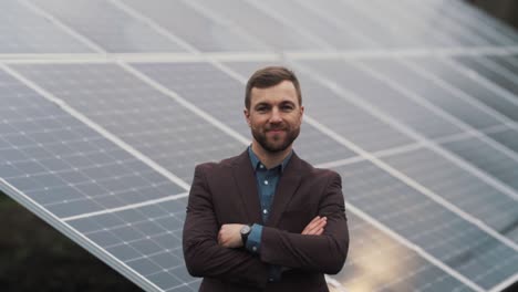 Close-up-of-serious-man-in-business-clothes-against-solar-power-plant-background-showing-thumbs-up