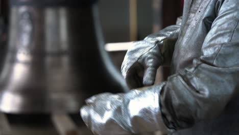 Bell-Casting-Foundry-Worker-Putting-on-Heat-Resistant-Gloves-SLOMO