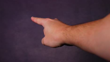Man's-hand-pointing-with-one-finger-to-front-of-gesture-captured-from-left-side-looking-gracefully-in-front-of-camera-with-leading-daylight-all-capture-in-4K-60fps-slow-motion-movement