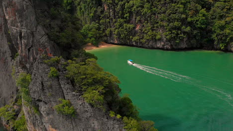 High-drone-view-of-a-speed-boat-approaching-the-deserted-beach-at-Pang-Na-Bay-on-Koh-Yao-Noi-Island-in-Thailand