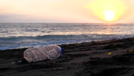 A-discarded-plastic-bottle-on-a-sandy-beach-at-sunset