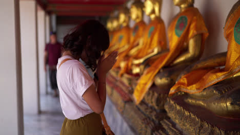 asian-woman-praying-with-buddha-in-temple