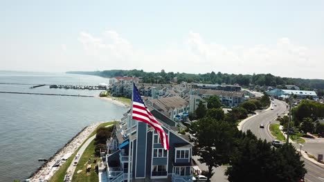 Aerial-View-on-American-Flag-Waving-on-Pole-on-Coast-of-Chesapeake-Bay,-Maryland-USA