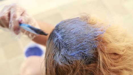 Mature-woman-dyeing-her-own-hair-with-a-comb-in-an-evening-24fps-slowmo-FullHD