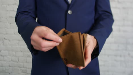 A-business-man-looking-for-cash-in-an-empty-wallet