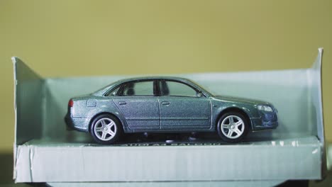 A-mini-vintage-metallic-grey-shiny-car,-360-rotating-stand