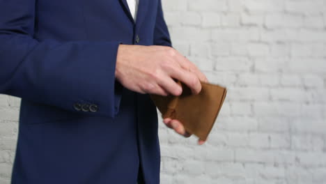 An-empty-wallet-being-opened-by-a-business-man-showing-that-he-has-no-money