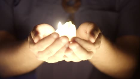 Close-up-view-of-the-candle-light-glowing-on-the-hands