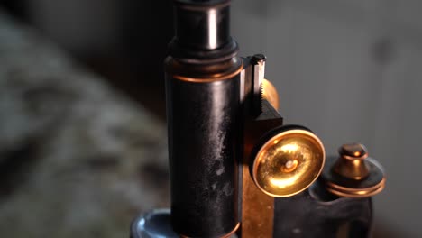 Blurred-then-push-in-to-reveal-an-antique-microscope-with-shiny-brass-knobs---macro