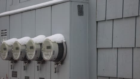Four-Hydrometers-Locked-And-Capped-With-Snow-On-The-Gray-Wall