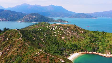 Paradiesischer-Geheimer-Strand-Mit-Weißem-Sandstrand-Auf-Tropischer-Insel-Mit-Felsigen-Hügeln,-Die-Von-Türkisfarbenem-Meerwasser-In-Cheung-Chau,-Hongkong-Umspült-Werden