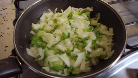 Closeup-Detail-of-Slowmo-Steam-Rising-Off-Onion-and-Green-Pepper-in-Frying-Pan