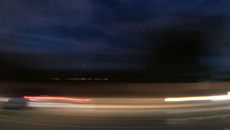 Driving-through-the-city-under-the-blue-night-sky---time-lapse