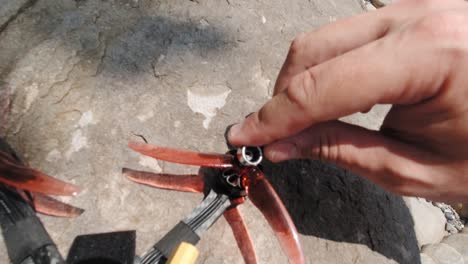A-man's-hand-tightening-the-loose-screws-of-drone-propellers-using-a-small-wrench---closeup-shot