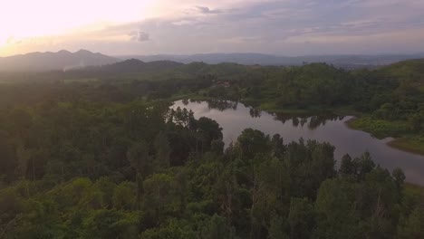 Drone-Revelando-Un-Lago-Con-Puesta-De-Sol-En-El-Fondo-En-Venezuela-Con-Un-Espectacular-Cielo-Naranja